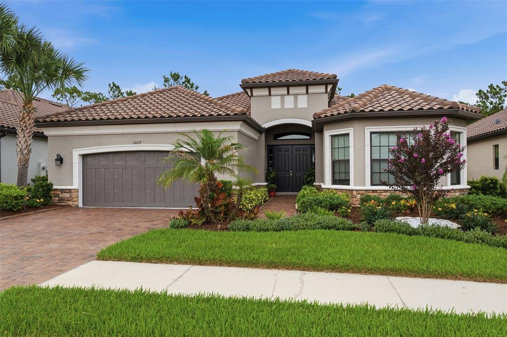 A single-story house with a paved driveway, a two-car garage, and palm trees — 20117 UMBRIA HILL DRIVE, TAMPA, FL