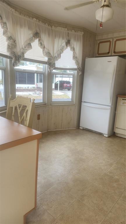 A kitchen dining area features a bay window, white refrigerator, and light-colored tile flooring — 157 N FIJI CIRCLE, ENGLEWOOD, FL