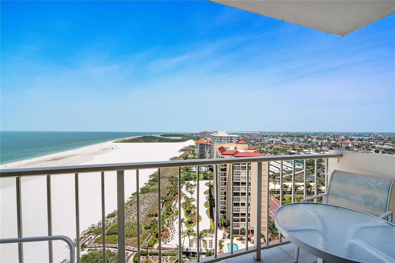 A high-angle view from a balcony overlooking a white sand beach and the ocean — 58 N Collier Boulevard # 2108, Marco Island FL 34145, MARCO ISLAND, FL