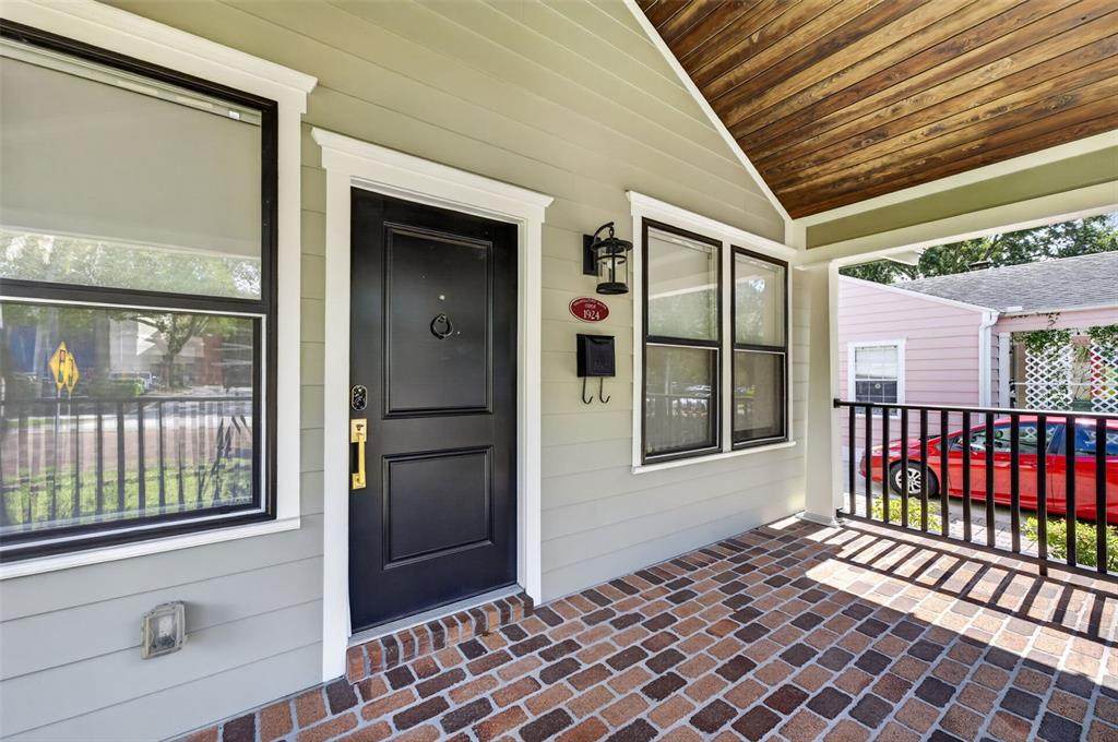 A covered porch with a brick floor leads to a black front door — 1225 E AMELIA STREET, ORLANDO, FL
