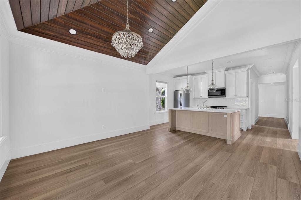 A dining area with a wood-paneled tray ceiling leads into a kitchen with an island — 1225 E AMELIA STREET, ORLANDO, FL