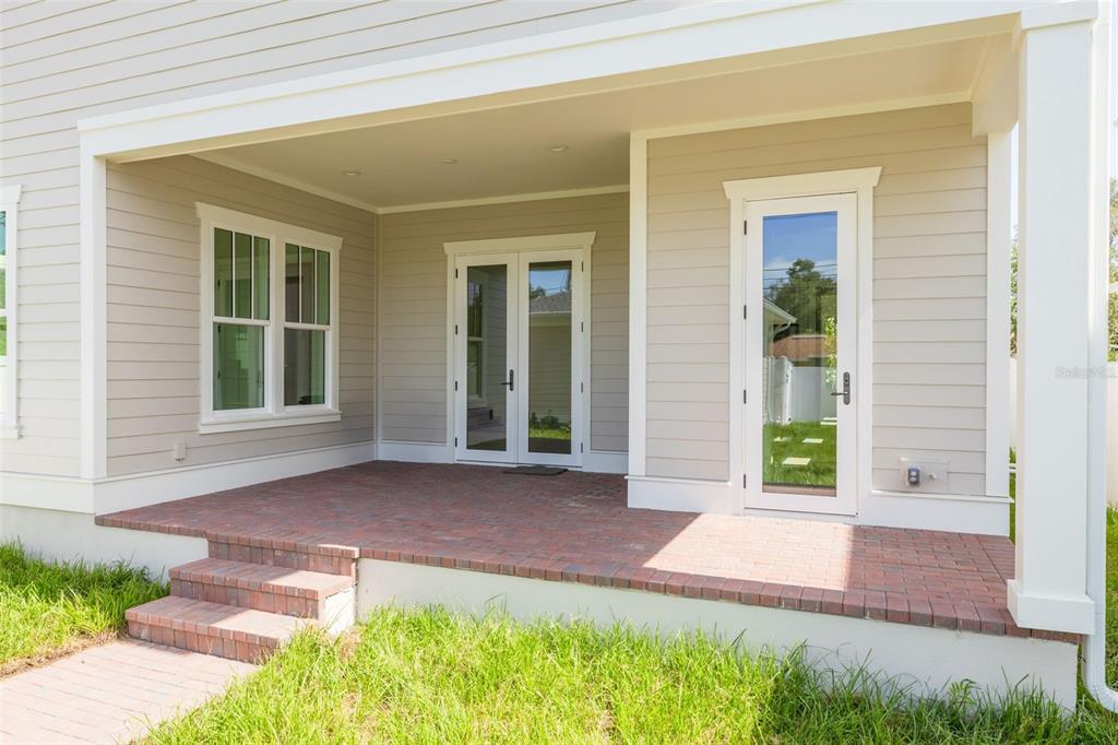 A covered brick patio features a set of French doors and a single glass door — 455 47TH AVENUE N, ST PETERSBURG, FL