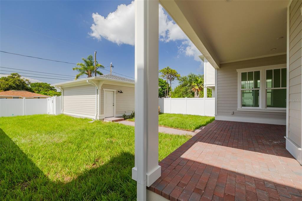 A view from a covered brick patio looking out toward a detached garage and yard — 455 47TH AVENUE N, ST PETERSBURG, FL