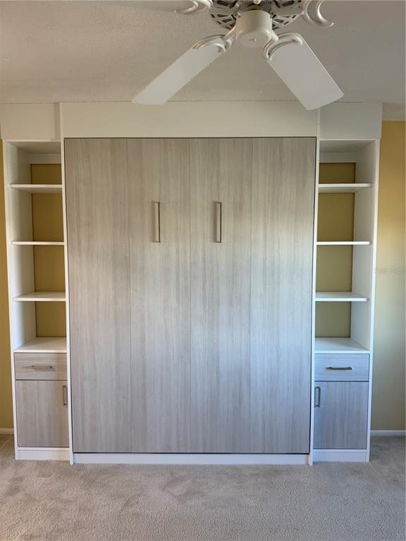 A room features a light wood-toned Murphy bed unit flanked by white open shelving and cabinets — 435 S GULFSTREAM AVENUE UNIT 906, SARASOTA, FL