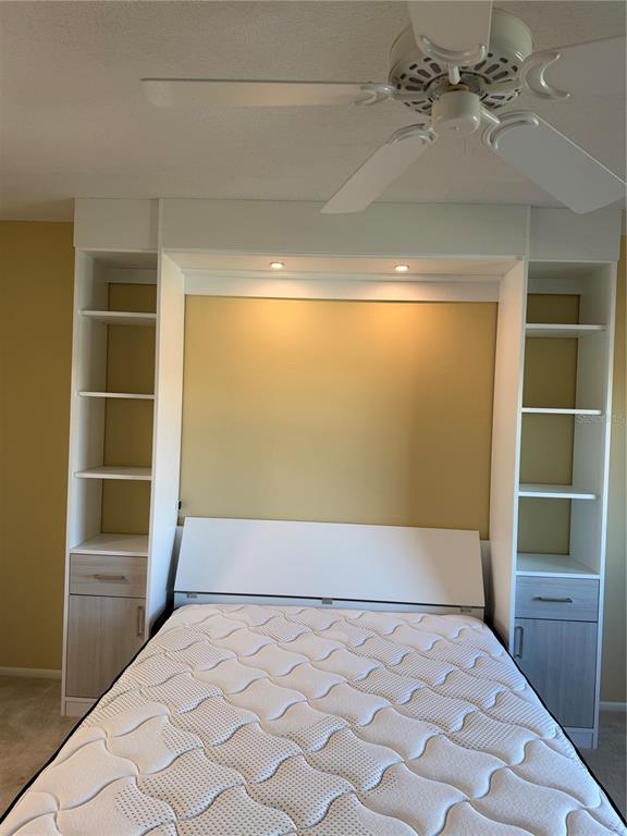 A bedroom features a white Murphy bed unit with built-in shelving and integrated lighting — 435 S GULFSTREAM AVENUE UNIT 906, SARASOTA, FL