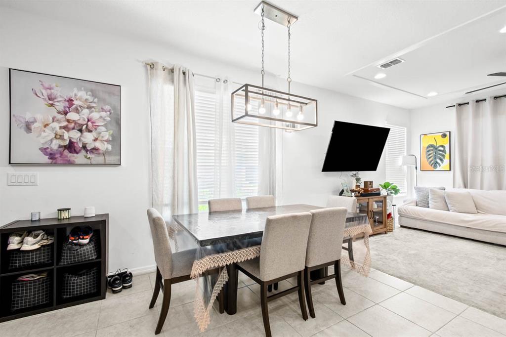 A dining area with a rectangular table, six chairs, and a modern rectangular pendant light — 6262 GOLDCOAST AVENUE, APOLLO BEACH, FL
