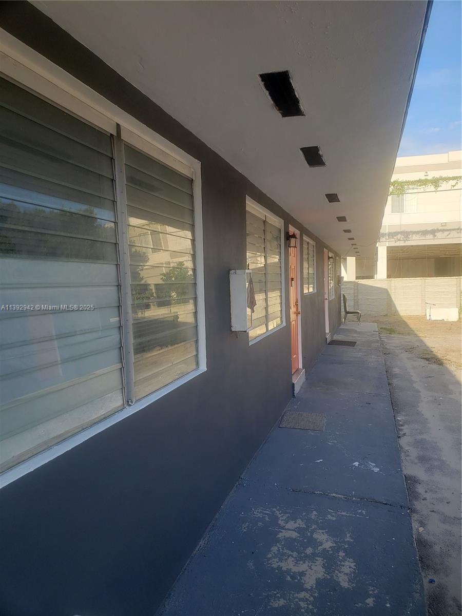 This exterior view shows a gray building with louvered windows and a concrete walkway — 2865 NW 22nd Ave, Miami FL 33142, MIAMI, FL