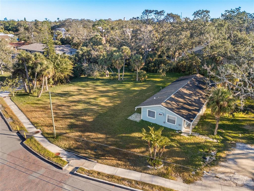 An aerial view shows a single-story house situated on a large, grassy corner lot — 404 CANAL STREET, TARPON SPRINGS, FL