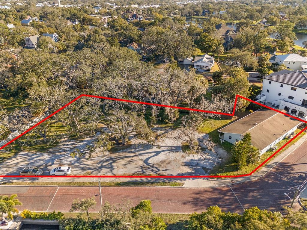An aerial view shows a vacant lot with trees and a small building outlined in red — 404 CANAL STREET, TARPON SPRINGS, FL