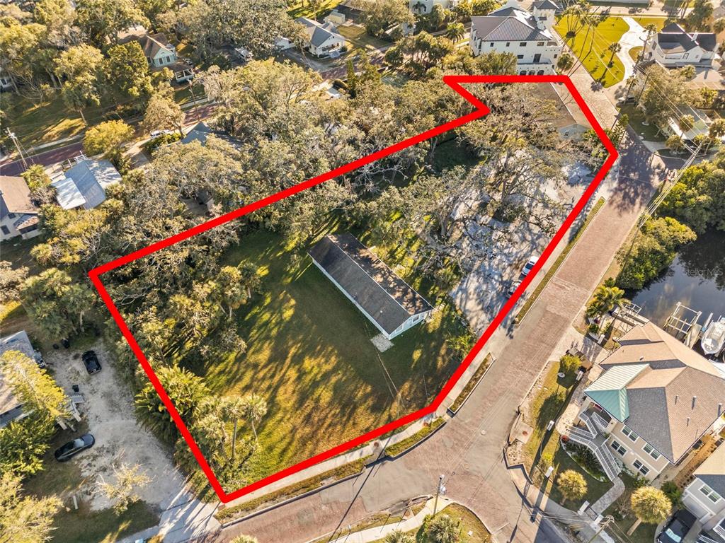An aerial view shows a rectangular house situated on a large, tree-covered corner lot — 404 CANAL STREET, TARPON SPRINGS, FL
