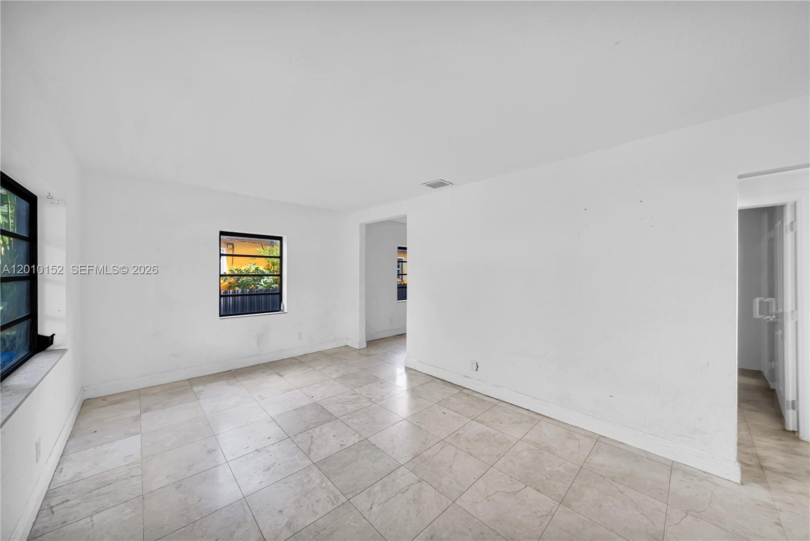 An empty room features white walls, light-colored tile flooring, and two windows — 3033 Hibiscus Street, Miami FL 33133, MIAMI, FL