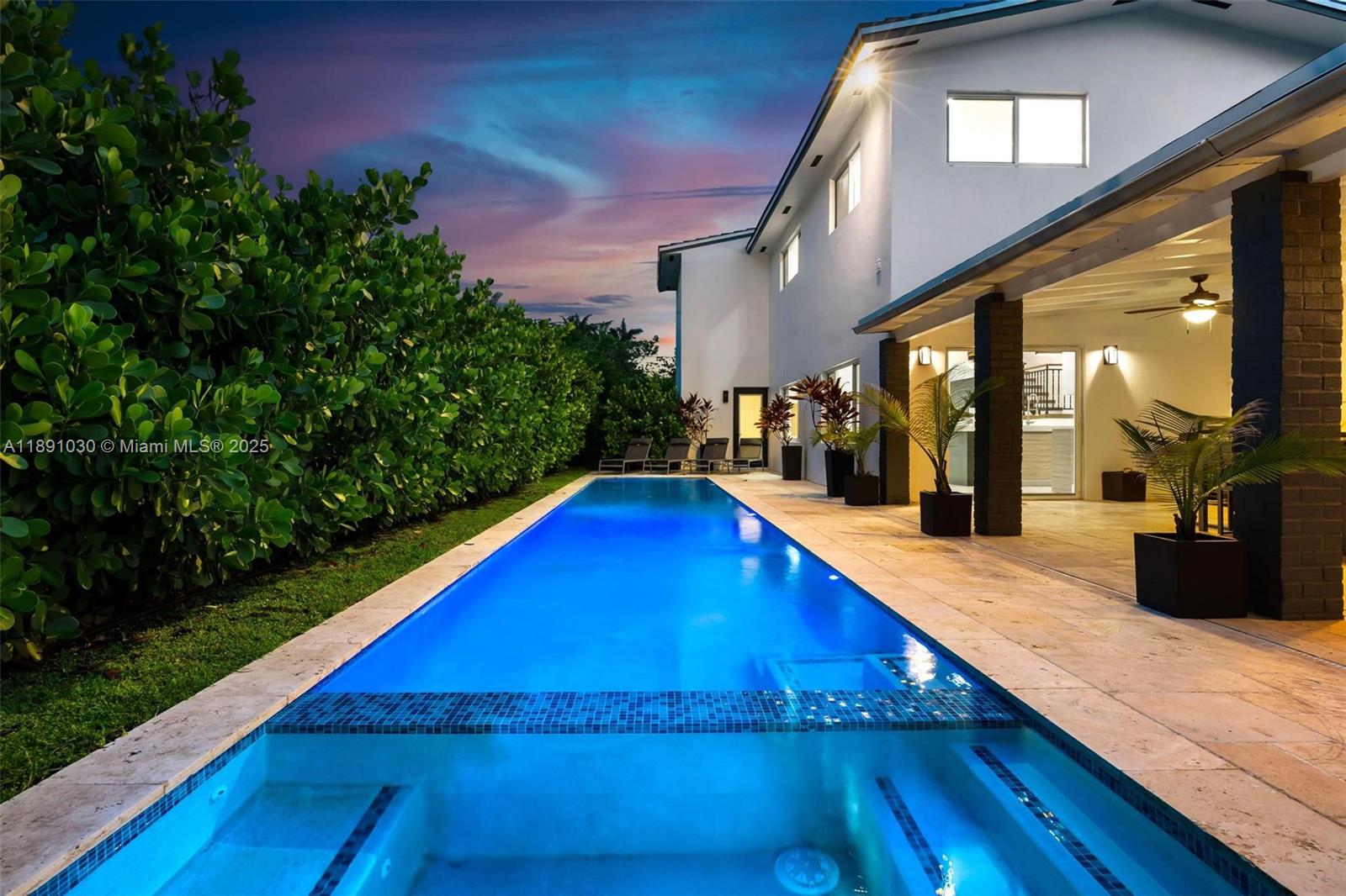 A long rectangular swimming pool sits beside a modern two-story house with a covered patio — 1651 SW 13th Ave, Miami FL 33145, MIAMI, FL