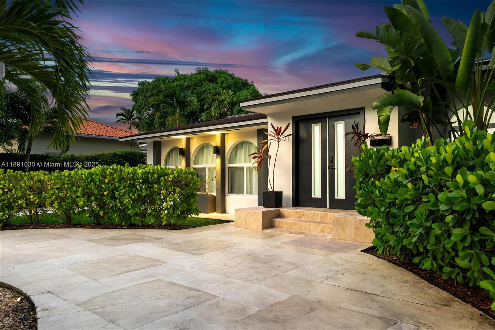 A modern house exterior features a stone driveway, arched windows, and double front doors — 1651 SW 13th Ave, Miami FL 33145, MIAMI, FL