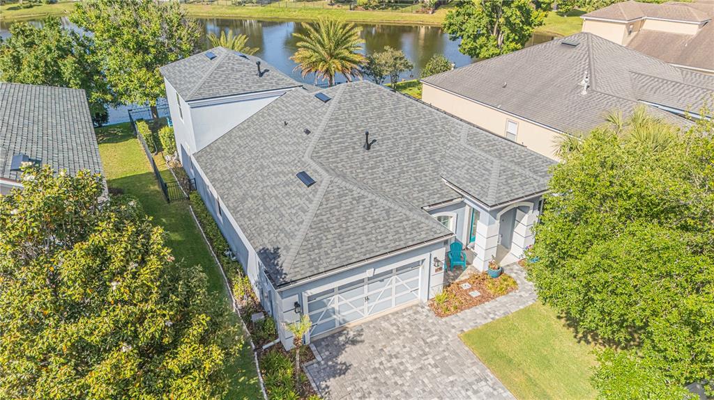 An aerial view of a suburban house with a gray shingled roof and paver driveway — 191 S ARABELLA WAY, ST JOHNS, FL
