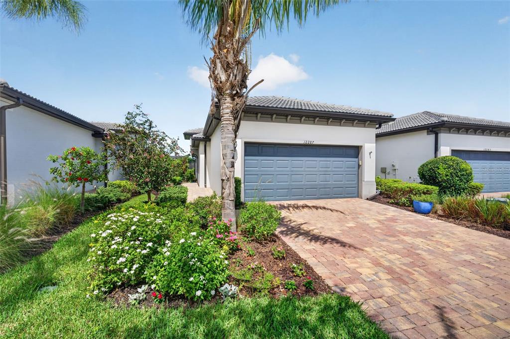 A single-story house with a paved driveway, a two-car garage, and landscaped front yard — 12287 MYRTLE BAY COURT, SARASOTA, FL