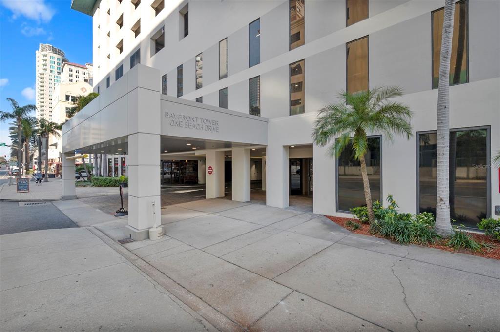 The exterior entrance of a multi-story building features a covered driveway and a palm tree — 1 BEACH DRIVE SE UNIT 1109, ST PETERSBURG, FL
