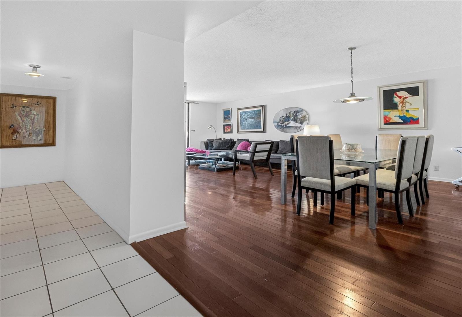A dining area and living room with hardwood floors and white walls — 600 Three Islands Boulevard # 406, Hallandale Beach FL 33009, HALLANDALE BEACH, FL