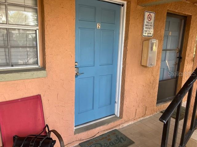 A blue door labeled number two sits next to a second door on a stucco exterior — 7710 BAYSHORE DRIVE UNIT 2, TREASURE ISLAND, FL