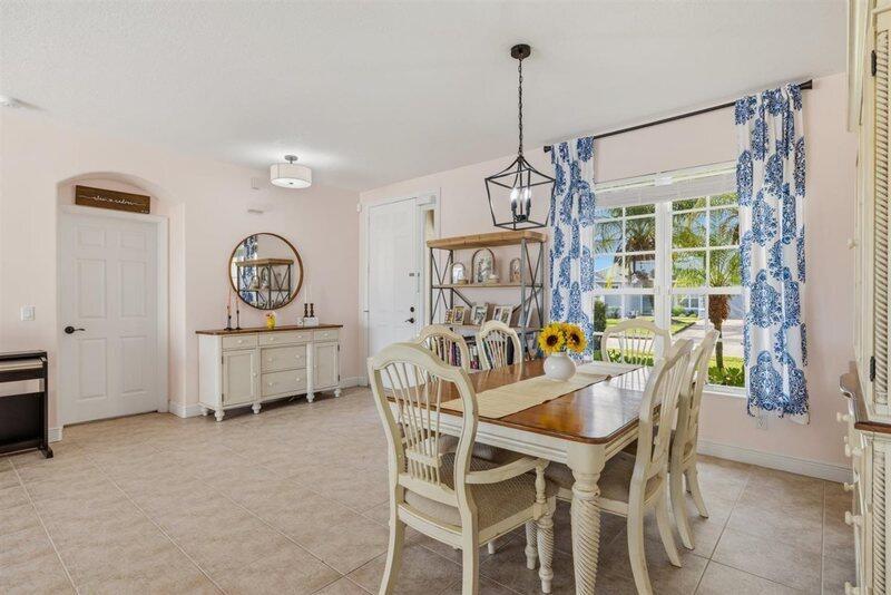A dining room features a wooden table, chairs, a sideboard, and a large window — VERO BEACH, FL