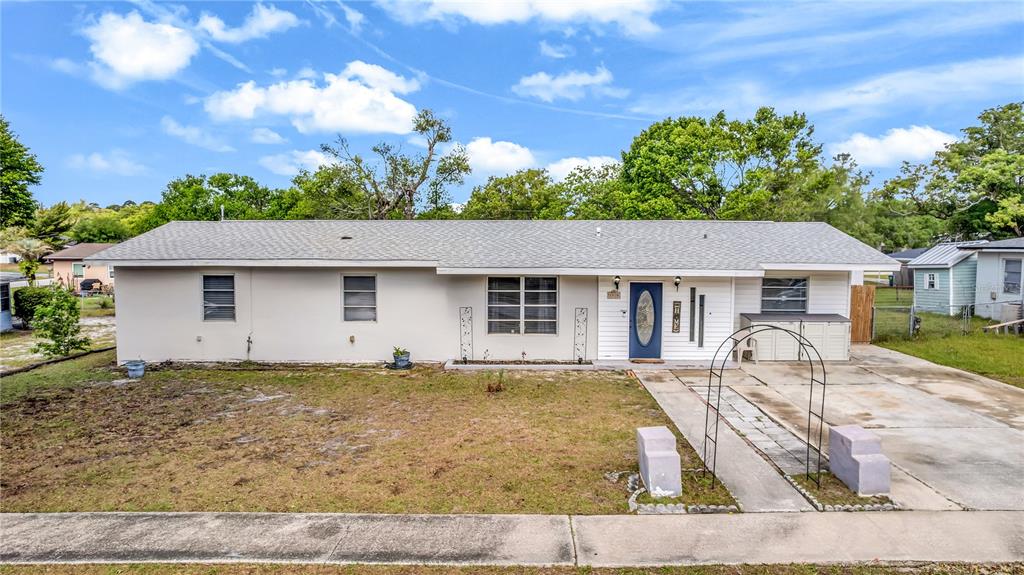 A single-story house with a light-colored exterior, a driveway, and a front yard — 1020 COBBLESTONE AVENUE, DELTONA, FL
