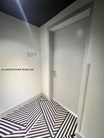 A modern apartment entrance with a numbered door and geometric patterned flooring — 45 SW 9th St # 3009, Miami FL 33130, MIAMI, FL