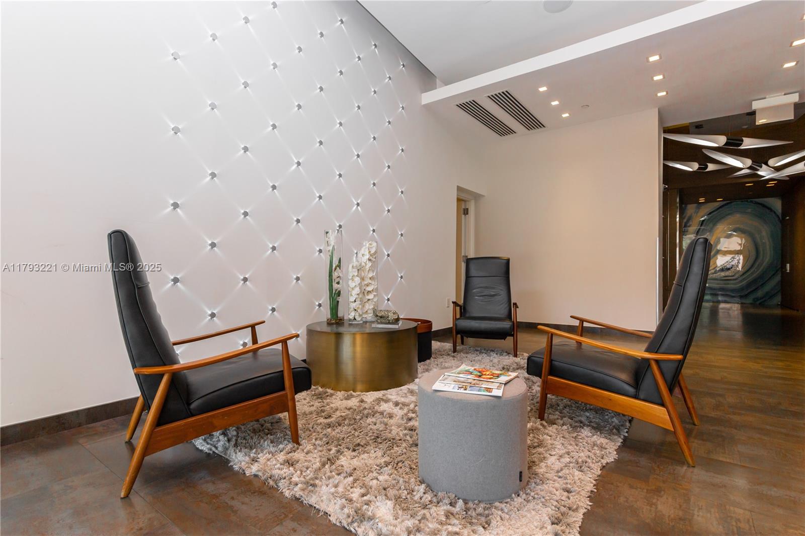 A modern lobby features three leather armchairs, a gold coffee table, and a lighted wall — 3250 NE 1st Ave # 608, Miami FL 33137, MIAMI, FL