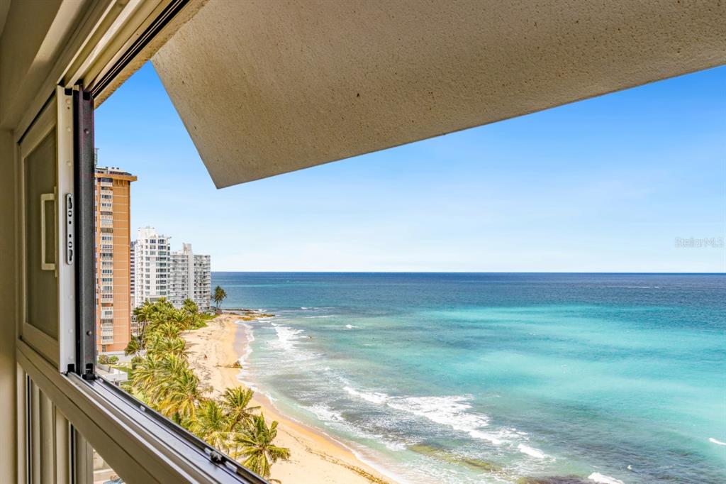 A view of the ocean and beach from an open window in a high-rise building — 1507 ASHFORD AVE. UNIT 1002, SAN JUAN, PR