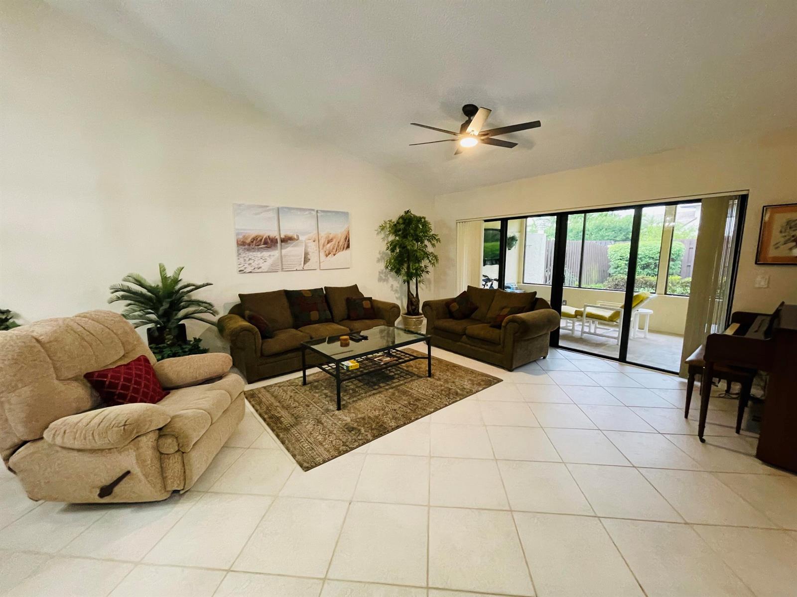 A living room features tile floors, two brown sofas, a recliner, and a glass coffee table — 354 SW 28th Avenue, Delray Beach FL 33445, DELRAY BEACH, FL
