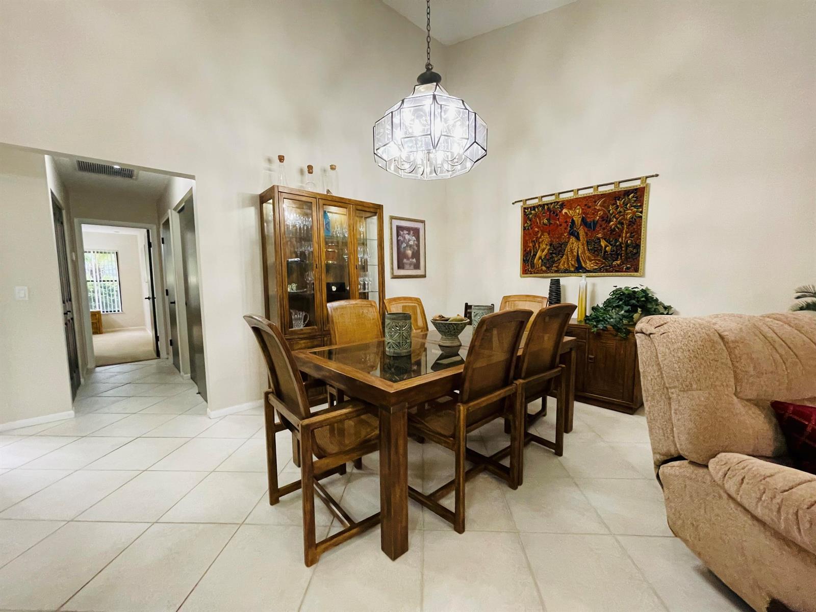 A dining room features a wooden table with six chairs, a china cabinet, and a chandelier — 354 SW 28th Avenue, Delray Beach FL 33445, DELRAY BEACH, FL