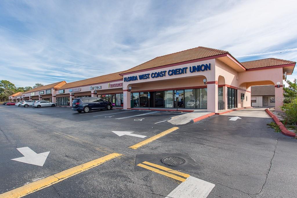 A strip mall exterior features a row of storefronts with a parking lot in front — 7200 RIDGE ROAD, PORT RICHEY, FL