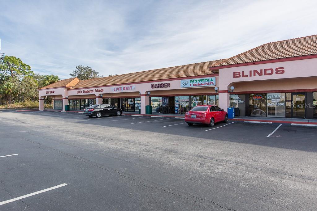 A single-story commercial strip mall with a parking lot in front — 7200 RIDGE ROAD, PORT RICHEY, FL