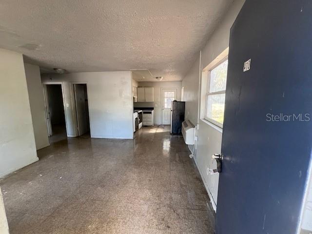 An interior view shows a living area leading to a kitchen with tiled floors — 410 TERRY STREET, WILDWOOD, FL