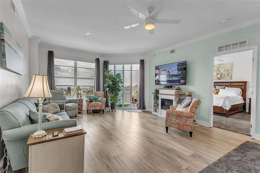 A living room with light wood floors, a fireplace, and a view of the water — 2801 S RIDGEWOOD AVENUE UNIT 502, SOUTH DAYTONA, FL