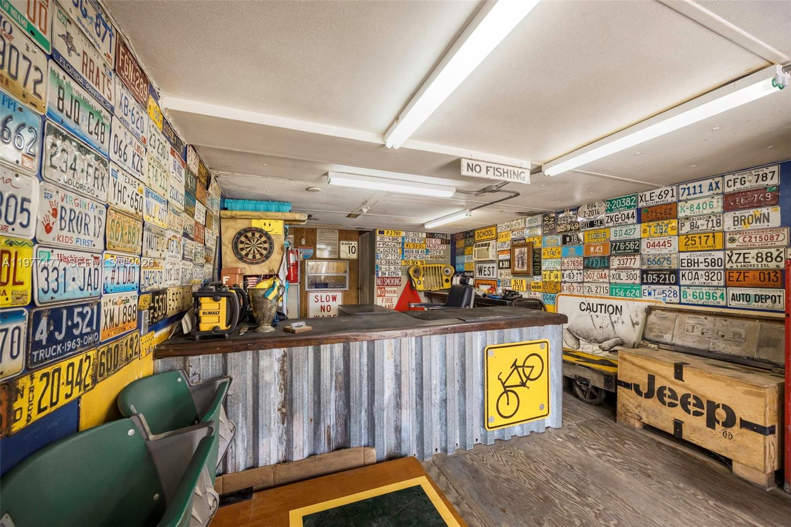 A room features a bar with corrugated metal siding and walls covered in license plates — 12880 Port Said Rd, Opa-Locka FL 33054, OPA-LOCKA, FL