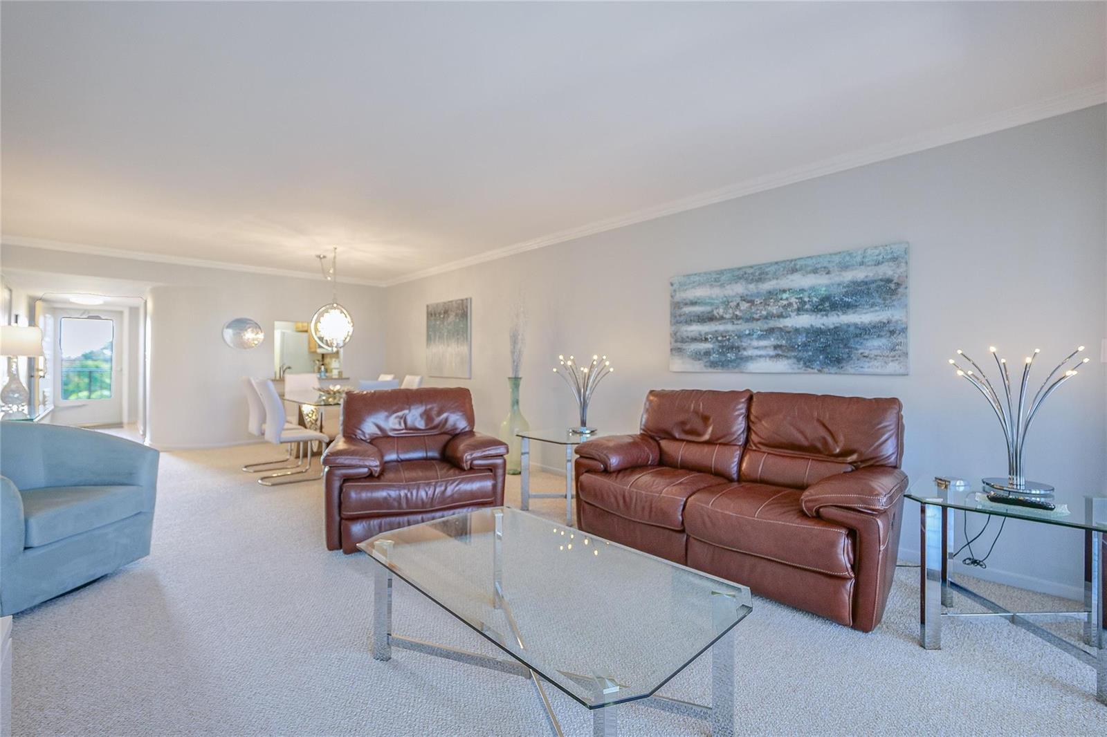 A living room features brown leather seating, a glass coffee table, and a dining area — 3920 Inverrary Boulevard # c, Lauderhill FL 33319, LAUDERHILL, FL