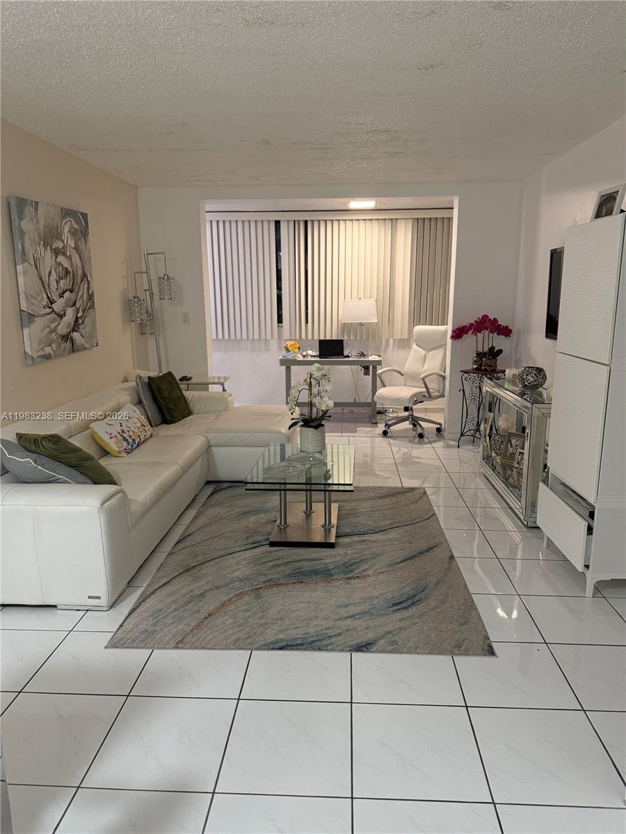A living room features white tile floors, a white sectional sofa, and a home office — 5033 NW 7th St # 312, Miami FL 33126, MIAMI, FL