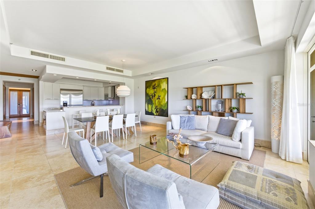 A bright open-concept living and dining area features tile flooring, white furniture, and modern decor — PH 404 PLANTATION VILLAGE II UNIT 404, DORADO, PR
