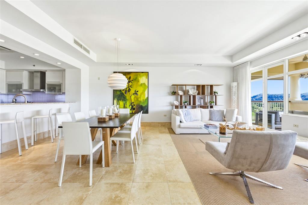 A bright, open-concept living and dining area features tile flooring, modern furniture, and a balcony — PH 404 PLANTATION VILLAGE II UNIT 404, DORADO, PR