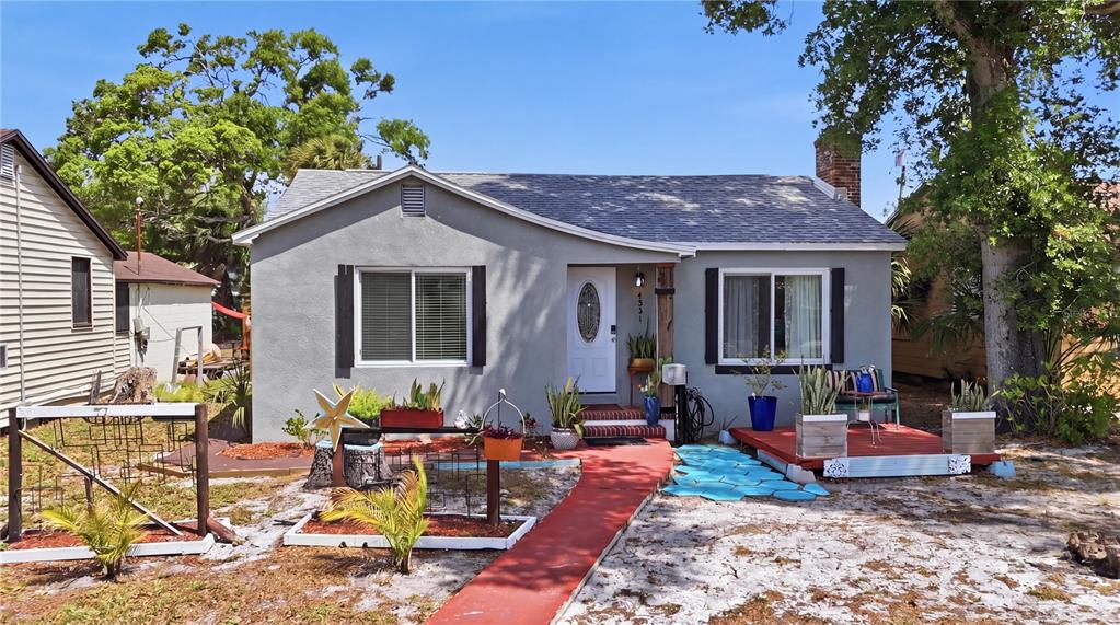 A gray single-story house features a red walkway, a front deck, and a white door — 4831 FAIRFIELD AVENUE S, ST PETERSBURG, FL