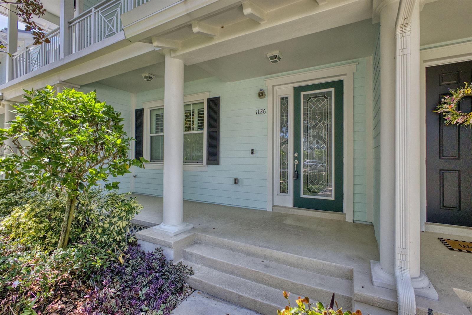 A light blue house exterior features a covered front porch with white columns and steps — 1126 Dakota Drive, Jupiter FL 33458, JUPITER, FL
