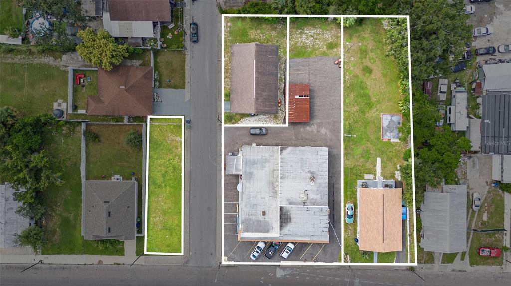 This aerial view shows several adjacent properties, including buildings, parking areas, and vacant lots — 3416 N 15TH STREET, TAMPA, FL