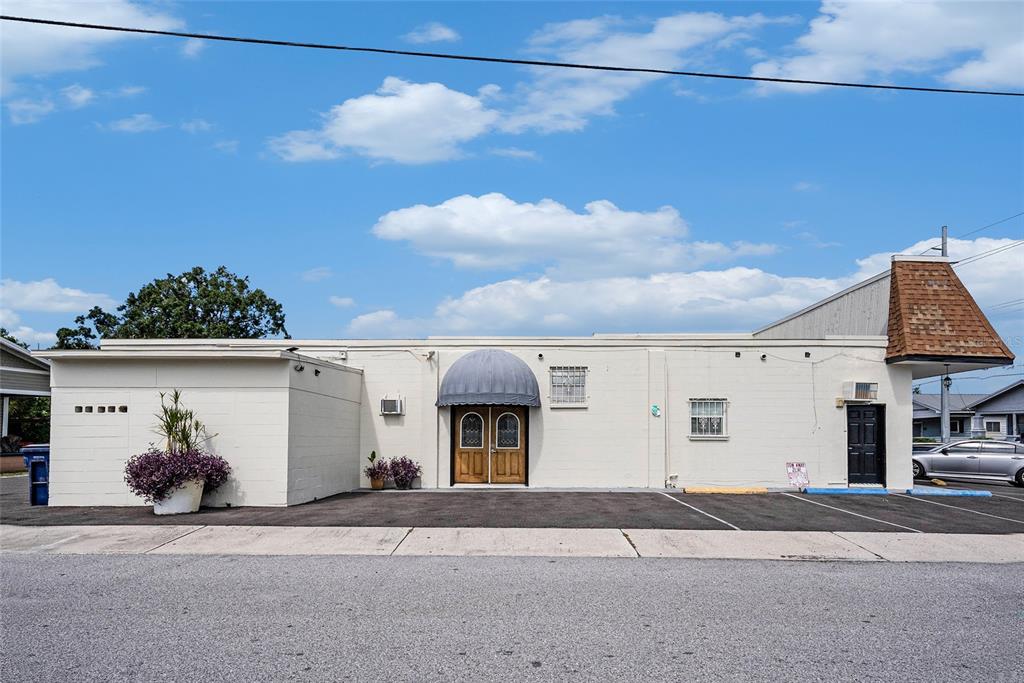 The exterior of a single-story commercial building features a central arched entrance and parking lot — 3416 N 15TH STREET, TAMPA, FL
