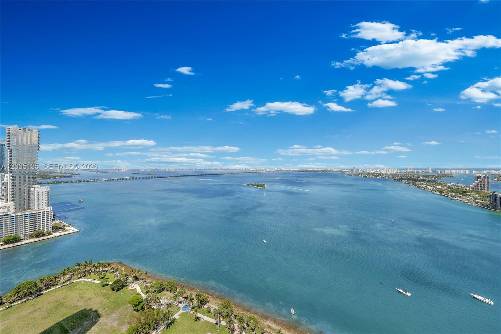 An aerial view shows a large bay with a bridge, coastal buildings, and a park — 488 NE 18th St # 3715, Miami FL 33132, MIAMI, FL