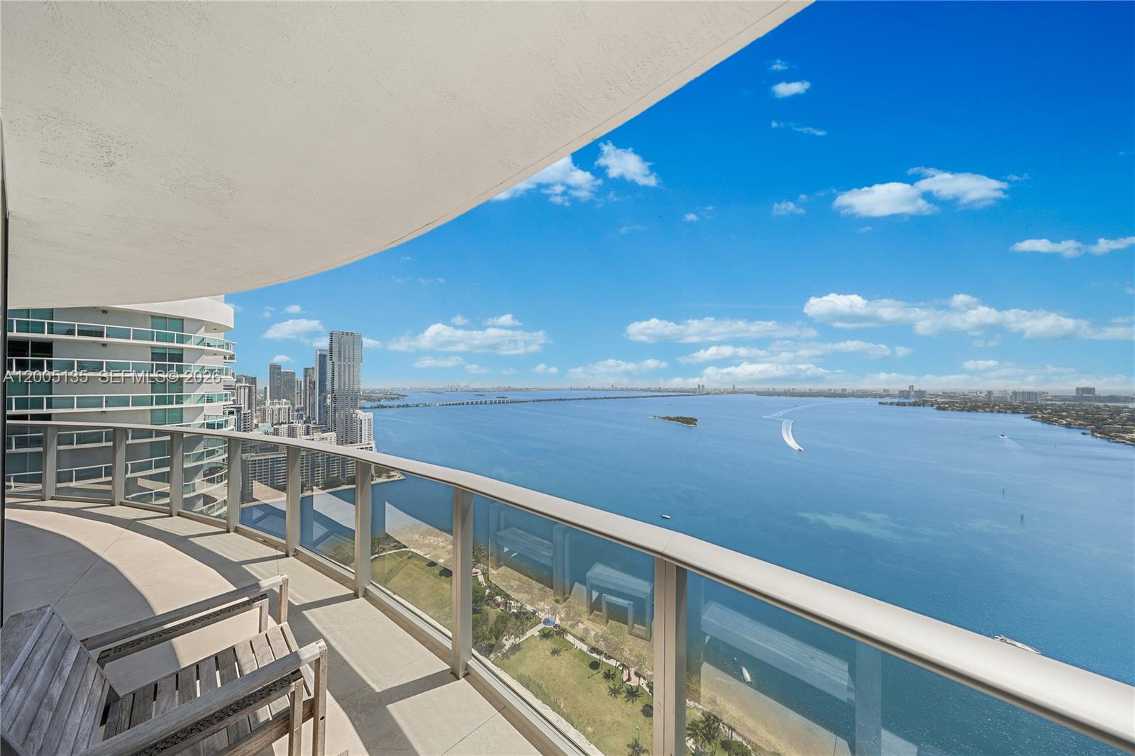 A high-rise balcony overlooks a large bay with city skyline views in the distance — 488 NE 18th St # 3715, Miami FL 33132, MIAMI, FL