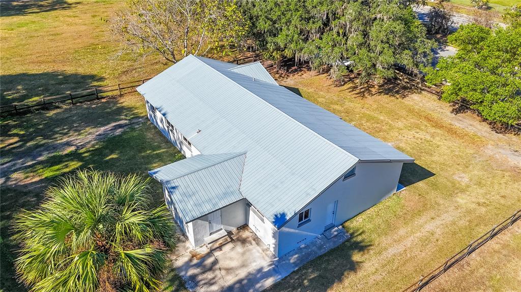 An aerial view shows a single-story house with a metal roof on a grassy lot — 1850 NW 35TH STREET, OCALA, FL