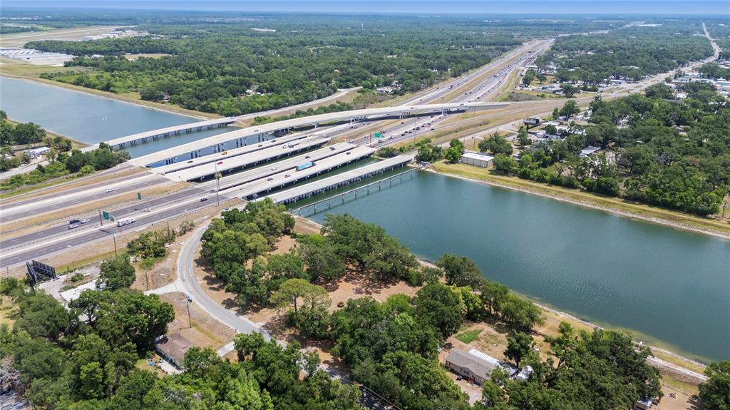 An aerial view shows a multi-lane highway bridge crossing over a large body of water — 5015 GARDEN LANE, TAMPA, FL