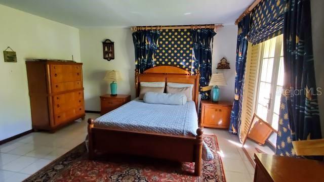 A bedroom features a wooden bed frame, matching dresser, nightstands, and patterned curtains — 27 SAN MIGUEL, HUMACAO, PR