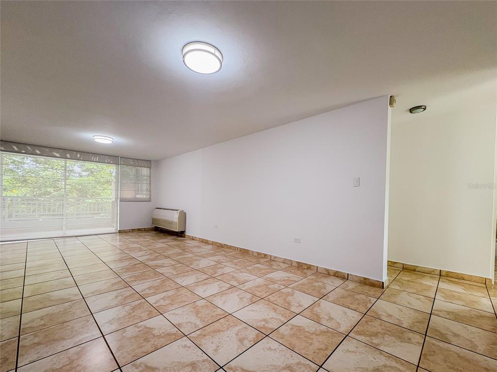 An empty room features beige tiled floors, white walls, two ceiling lights, and a balcony — 59 CLL UNION COND. HILLSVIEW PLAZA UNIT 107, GUAYNABO, PR