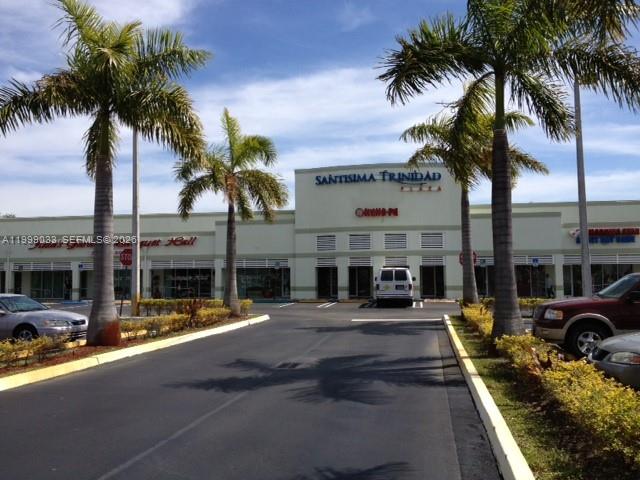 A strip mall exterior features a parking lot, palm trees, and a Santisima Trinidad Plaza sign — 2701 SW 142nd Ave # 2705, Miami FL 33175, MIAMI, FL