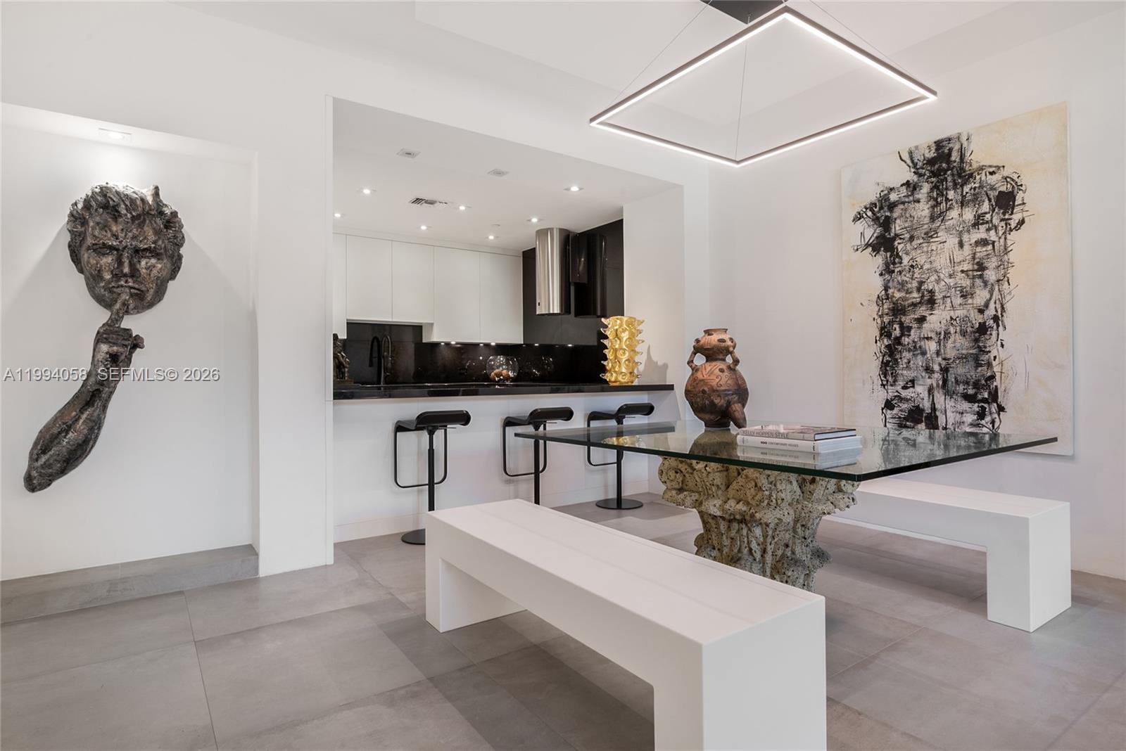 A modern dining area features a glass table with a stone base and white benches — 201 Crandon Blvd # 227, Key Biscayne FL 33149, KEY BISCAYNE, FL